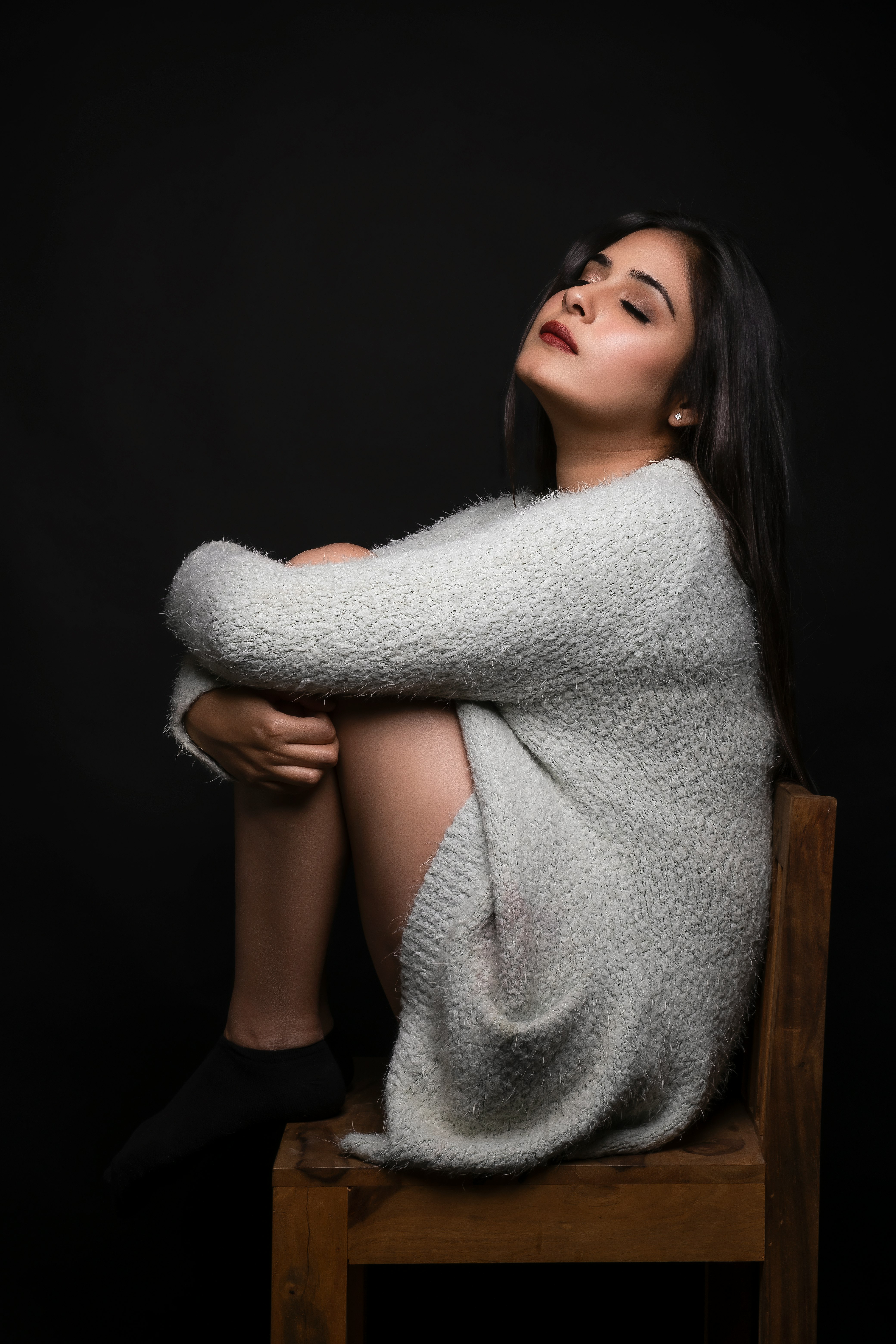 woman in white bath robe sitting on brown wooden seat